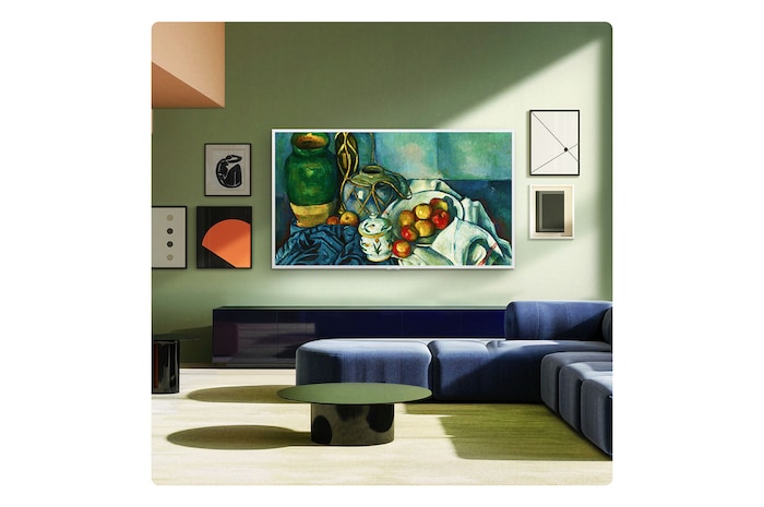 LG Gallery TV AI with frame LX7 ART TV with a Snow White Attachable Frame is in a living room, displayed on the wall, giving the room a gallery-like feel. On the screen is a colorful oil painting with realistic-looking brushstrokes.